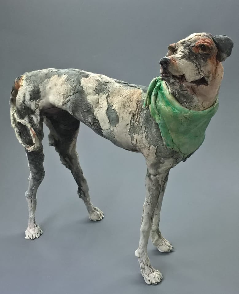 Sculpture of a lurcher dog with green neckerchief