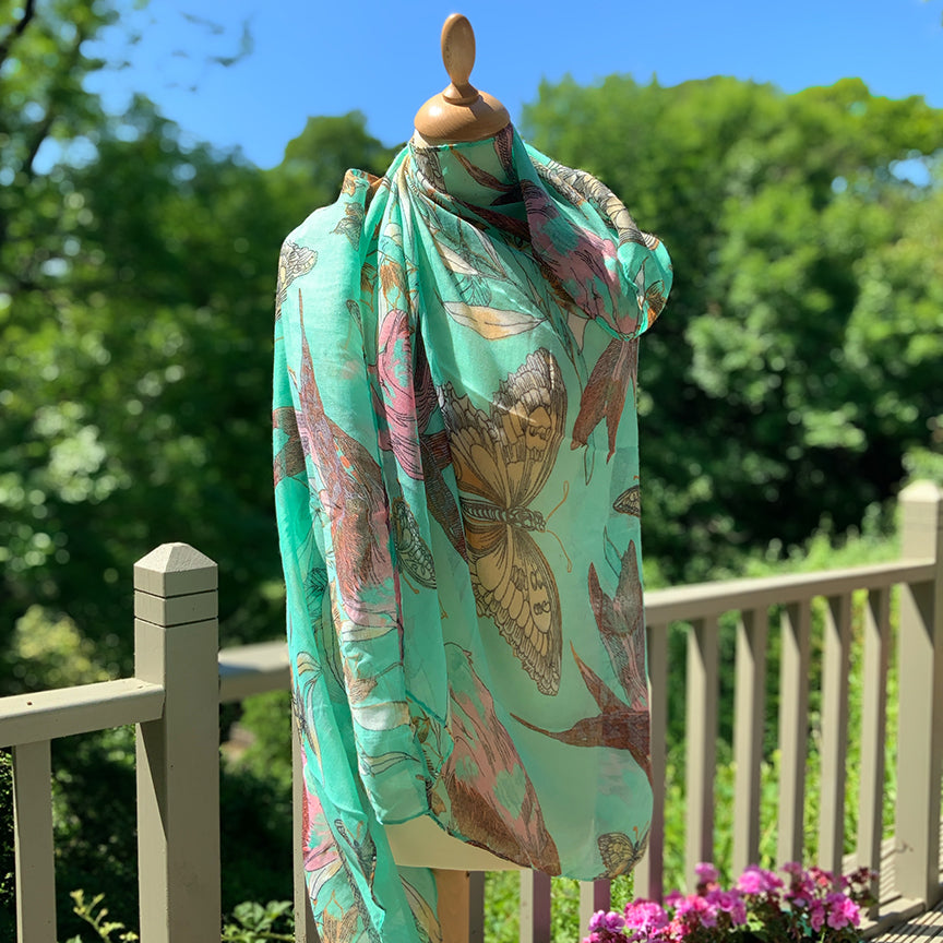 Pale green bird and butterfly design scarf in light floaty fabric.