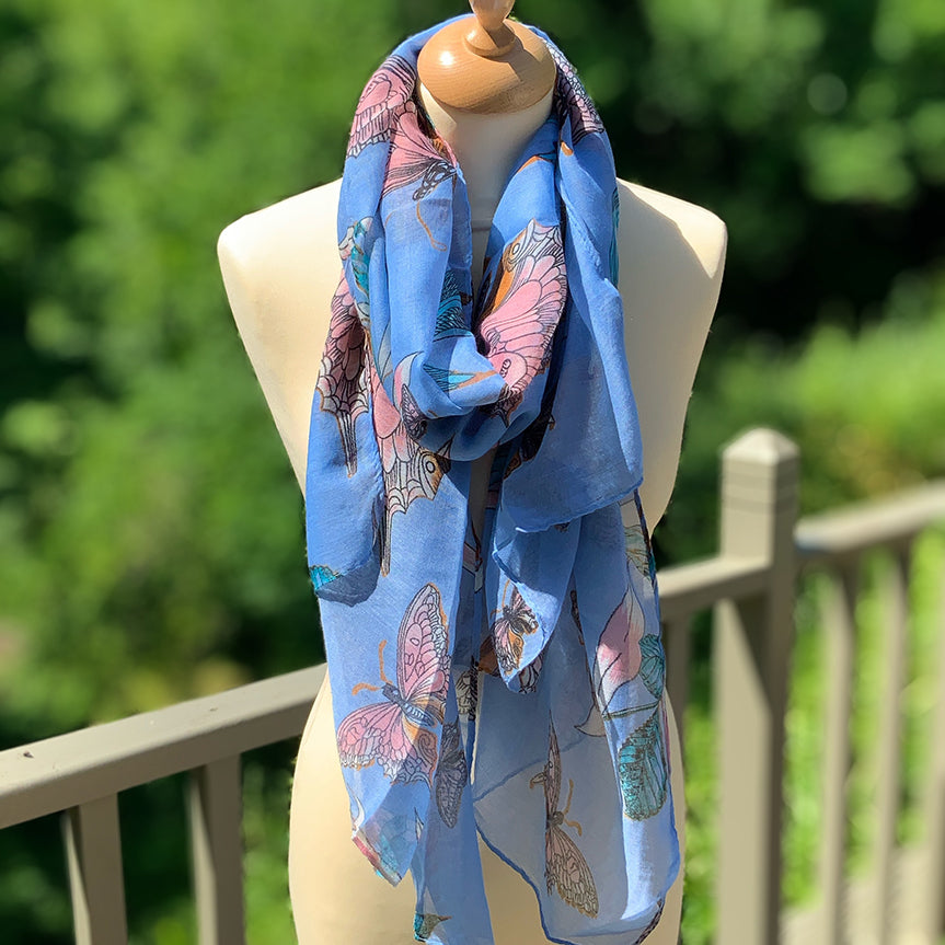 Pale blue butterfly patterned scarf, light weight draped  on a mannaquin