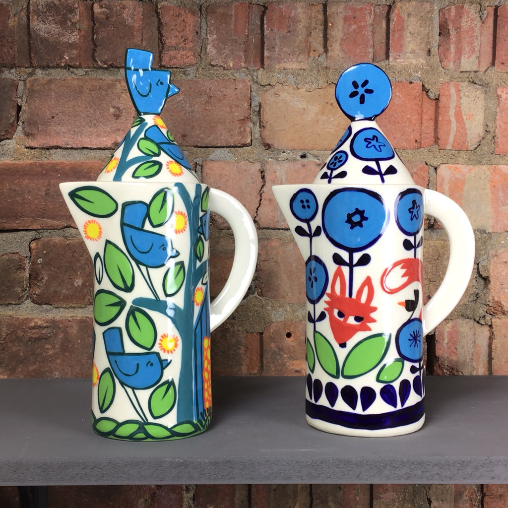Coffee pot with birds and fox design in blue and green.