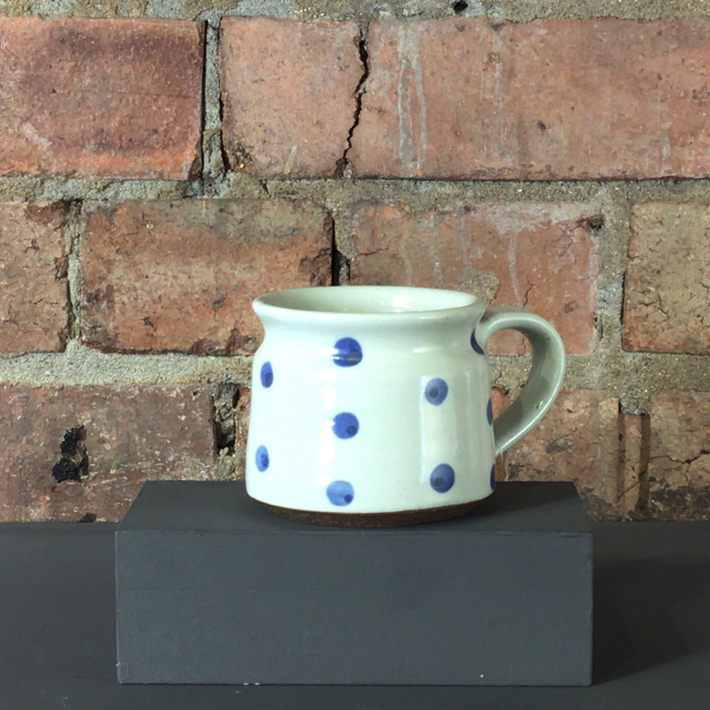 Cream ceramic mug with blue spots.