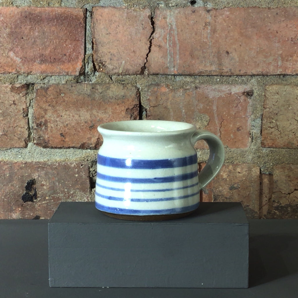 blue and white striped mug with a curved shaped rim.