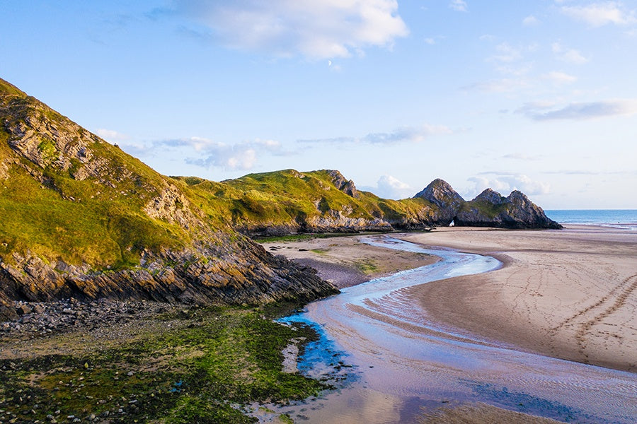 Three Cliffs Bay, on Gower seen from the edge of the river as it meanders into the sea.