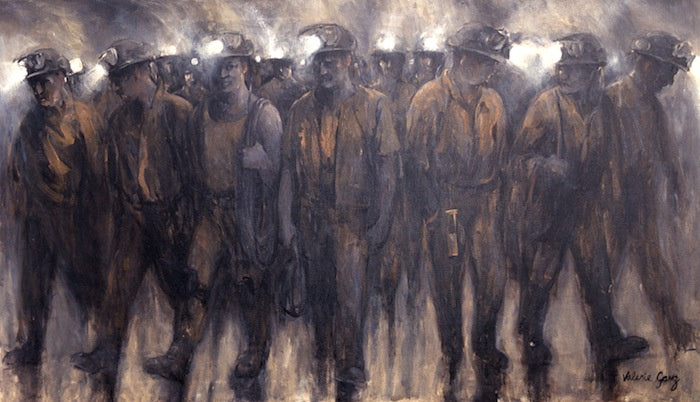 Group of miners leaving work after their shift wearing headtorches and burn orange clothing.
