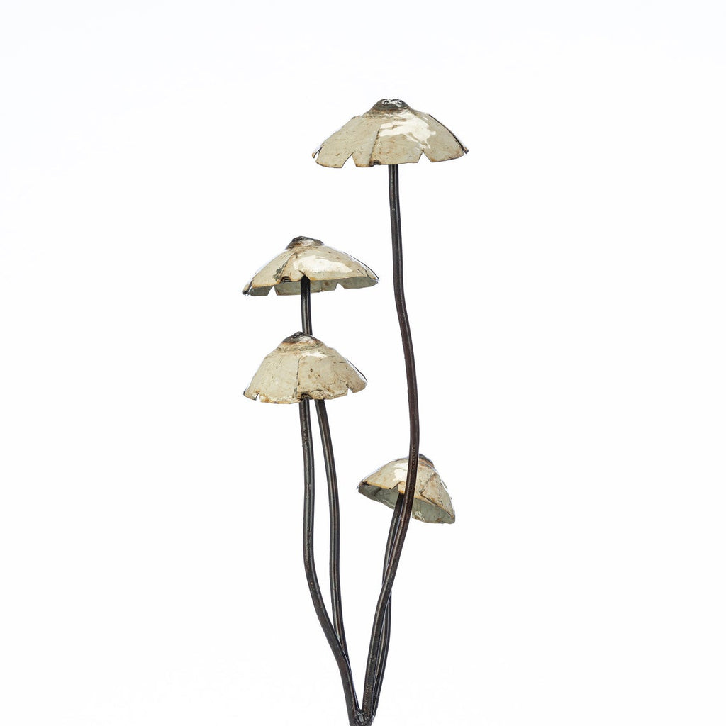 Large metal mushrooms for planting in a garden.